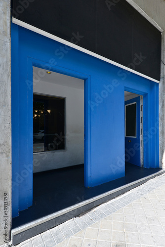 Facade of a local with walls painted in blue and black sign