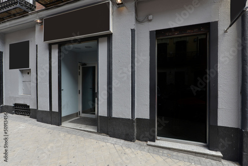 Local facade with gray stone walls, black details and black signs © Toyakisfoto.photos