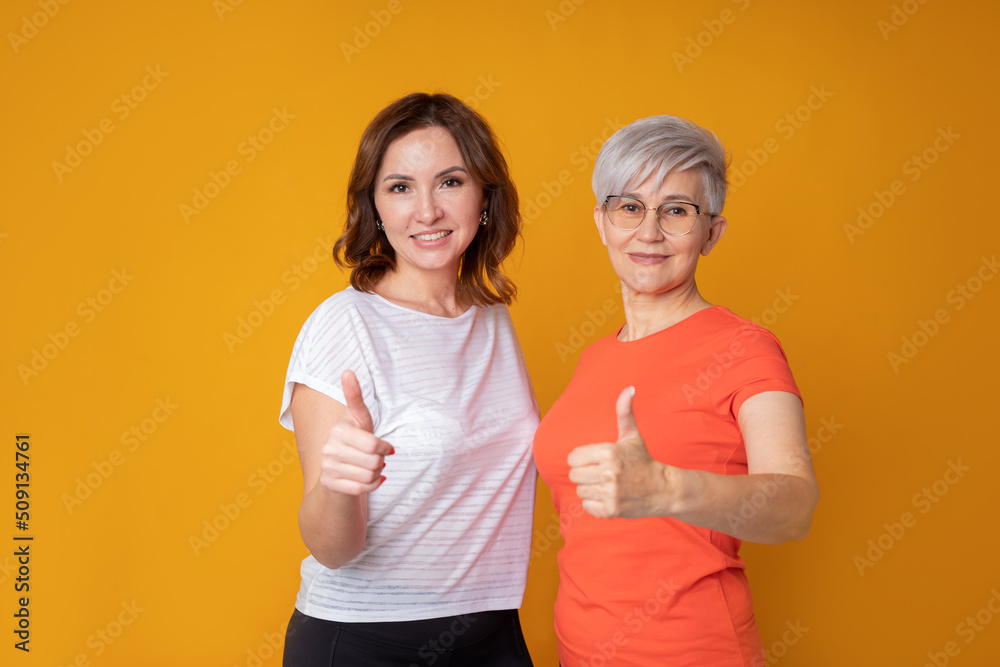 two adult caucasian women in sportswear with hand gesture two adult caucasian women in sportswear with hand gesture
