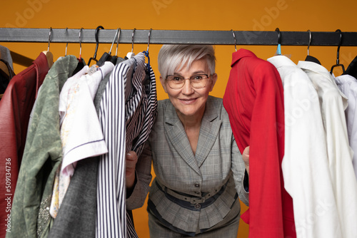 surprised adult woman peeks out from under things photo