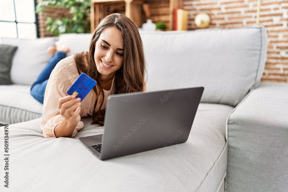 Young hispanic woman smiling confident using laptop and credit card at home Young hispanic woman smiling confident using laptop and credit card at home