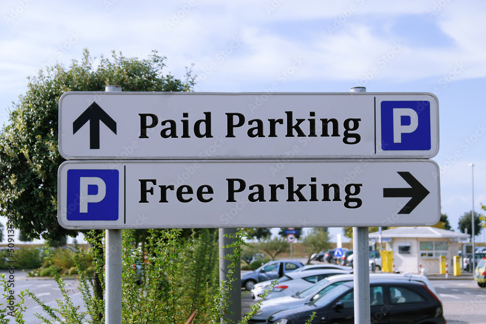 Road signs showing Paid Parking and Free Parking. Life choice strategy.