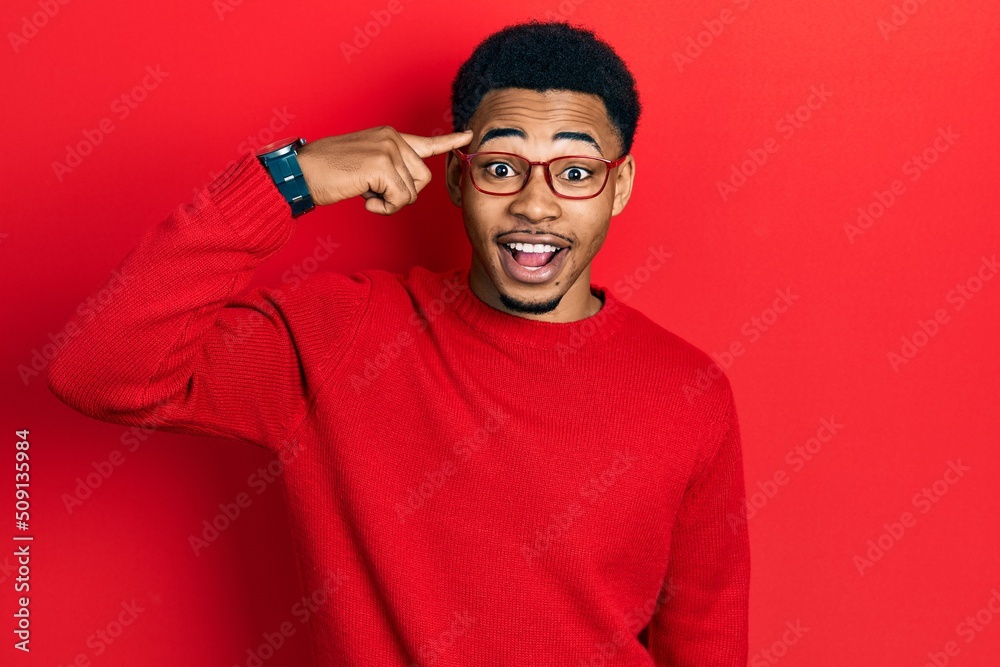 Young african american man pointing head with finger celebrating crazy and amazed for success with open eyes screaming excited. Young african american man pointing head with finger celebrating crazy and amazed for success with open eyes screaming excited.
