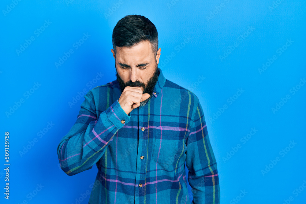 Young hispanic man wearing casual clothes feeling unwell and coughing as symptom for cold or bronchitis. health care concept. Young hispanic man wearing casual clothes feeling unwell and coughing as symptom for cold or bronchitis. health care concept.