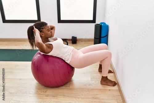 Photography Young african american woman training abs exersice at sport center
