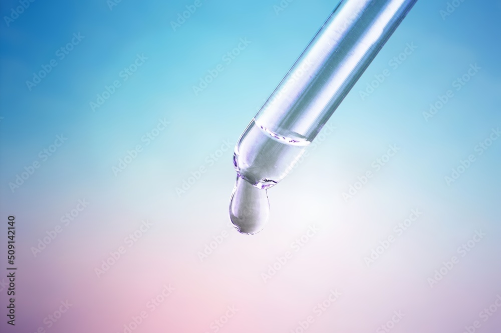 Glass lab dropper with a drop hanging from it on violet background, Abstract cosmetic ingredients formulating concept Glass lab dropper with a drop hanging from it on violet background, Abstract cosmetic ingredients formulating concept
