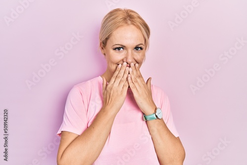фотографія Young blonde woman wearing casual pink t shirt laughing and embarrassed giggle c