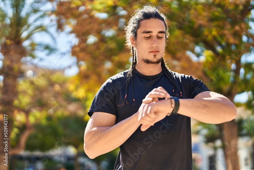 Young man using stopwatch at park