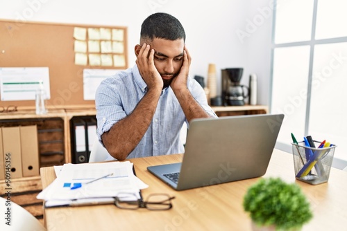 Young arab man stressed working at office