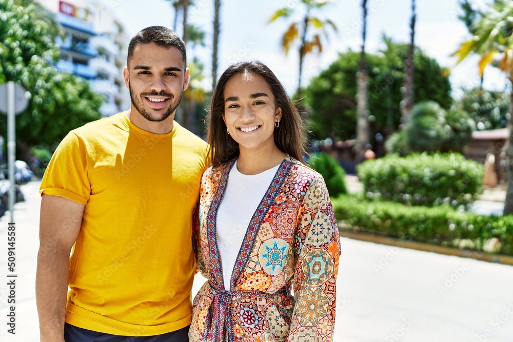 Naklejka premium Young latin couple smiling happy and hugging at the city.