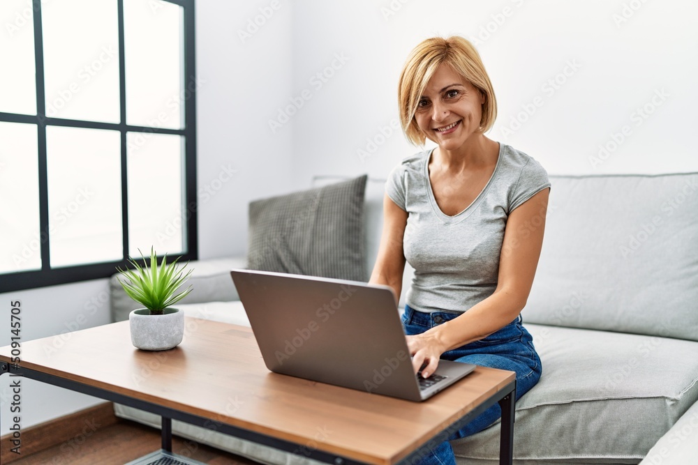 Middle age blonde woman smiling confident using laptop at home Middle age blonde woman smiling confident using laptop at home