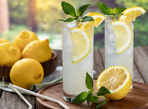 Two glasses of cold lemonade with rural background