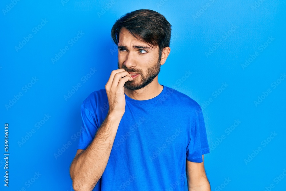 Young hispanic man wearing casual clothes looking stressed and nervous with hands on mouth biting nails. anxiety problem. Young hispanic man wearing casual clothes looking stressed and nervous with hands on mouth biting nails. anxiety problem.