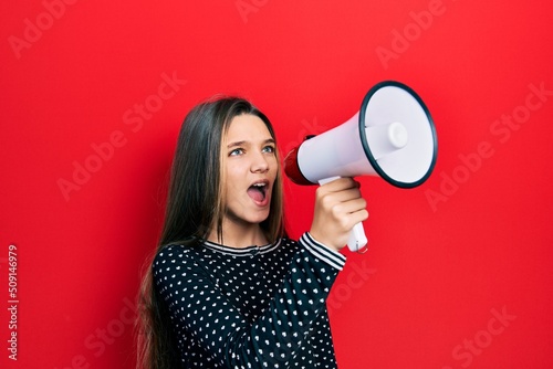 Young teenager girl shouthing and screaming with megaphone