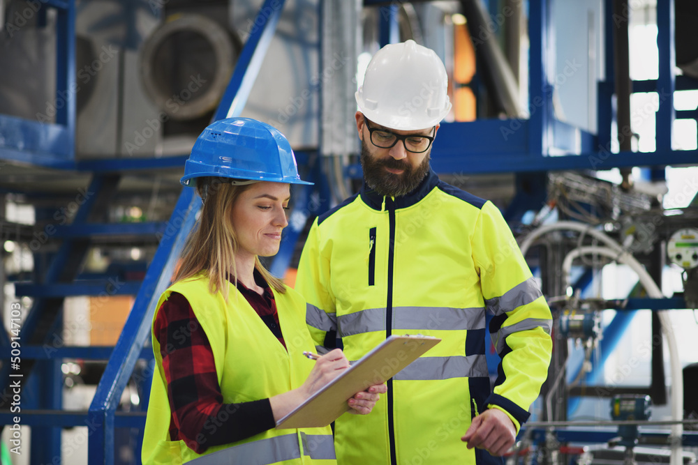 Engineering manager and mechanic worker doing routine check up in industrial factory Engineering manager and mechanic worker doing routine check up in industrial factory