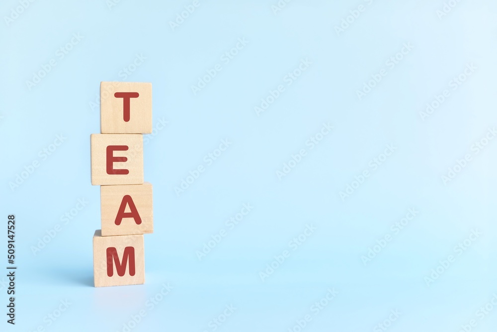 Team building and teamwork concept. Human hand stacking wooden blocks with word team. Team building and teamwork concept. Human hand stacking wooden blocks with word team.
