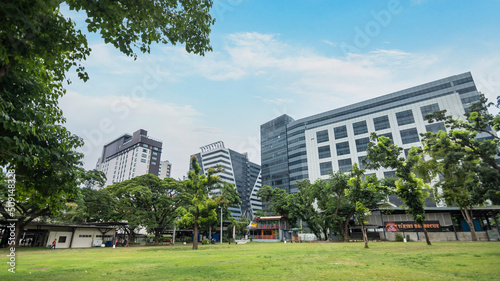 Konstfotografi Apas, Cebu City, Philippines - An open field area with trees and standalone restaurants with BPO Office towers at the back