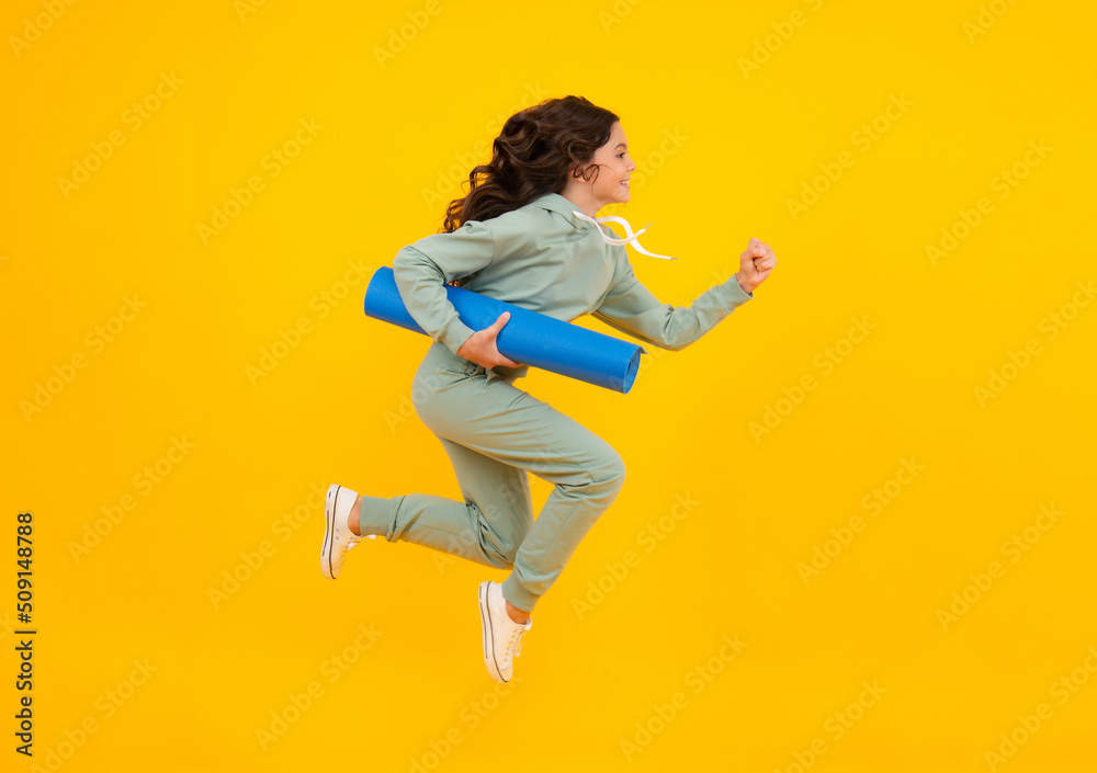 Amazed teen girl. Teen girl 12, 13, 14 years old in sport suit. Fashion child in sportswear sportive clothing. Sportive fashionable outfit. Studio shot on yellow background. Run and jump.