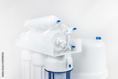 Bild auf Leinwand White and blue water filtration osmosis system with a carbon filter for clear wa