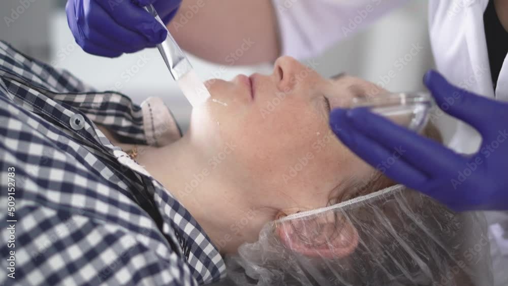 Cosmetologist smoothes wrinkles with microcurrent. Hardware procedure in cosmetology. Peeling, phonophoresis, massage and facelift in a beauty clinic. Cosmetologist smoothes wrinkles with microcurrent. Hardware procedure in cosmetology. Peeling, phonophoresis, massage and facelift in a beauty clinic.