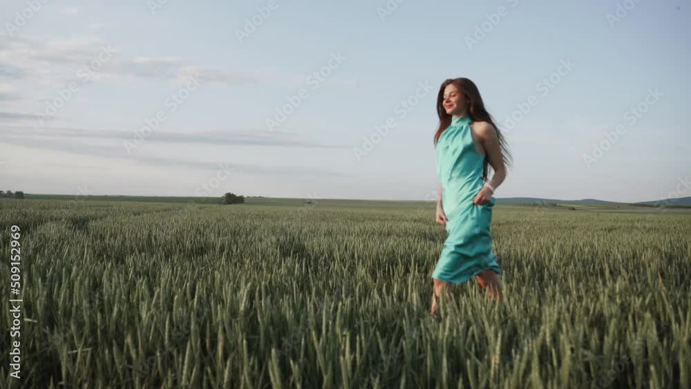 Young beautiful woman in long turquoise dress in summer field. Concept of freedom. walking in amazing green field Young beautiful woman in long turquoise dress in summer field. Concept of freedom. walking in amazing green field