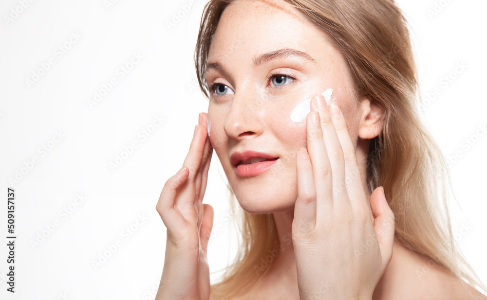 Young woman applies moisturizer to protect delicate skin. Beauty portrait on white background Young woman applies moisturizer to protect delicate skin. Beauty portrait on white background