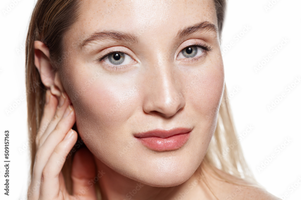 Beauty portrait of young woman with a light sensitive skin. Portrait with bare shoulders on a white background Beauty portrait of young woman with a light sensitive skin. Portrait with bare shoulders on a white background