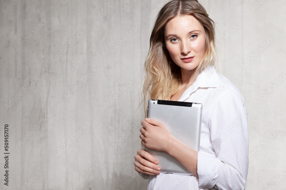 Waist up portrait of attractive business woman with nice smile in white shirt. Beautiful girl standing with gadget and looking away with happiness Waist up portrait of attractive business woman with nice smile in white shirt. Beautiful girl standing with gadget and looking away with happiness