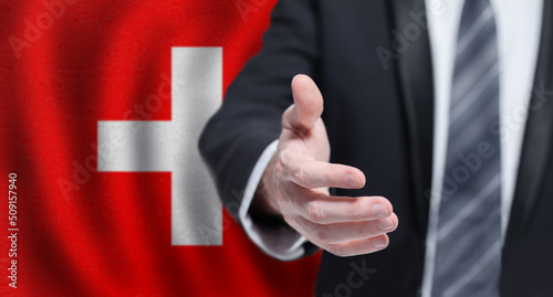 Swiss business, politics, cooperation and travel concept. Hand on flag of Switzerland background.