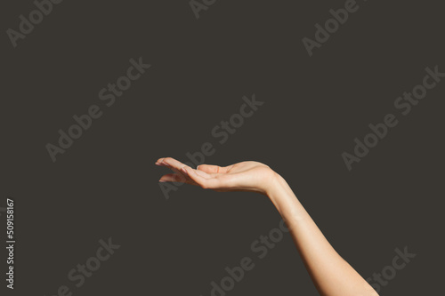 Beautiful open woman palm hand gesture on black background