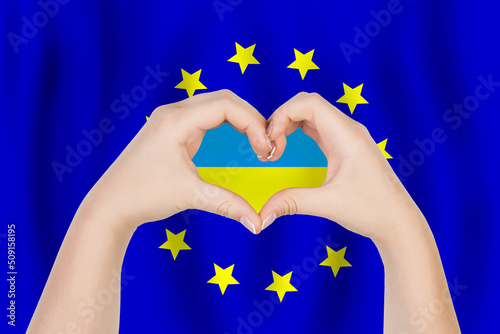 Hands making heart shape with flag of Ukraine on EU flag background