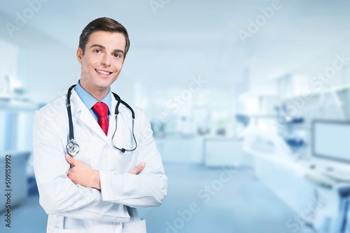 Happy young doctor in a white coat posing