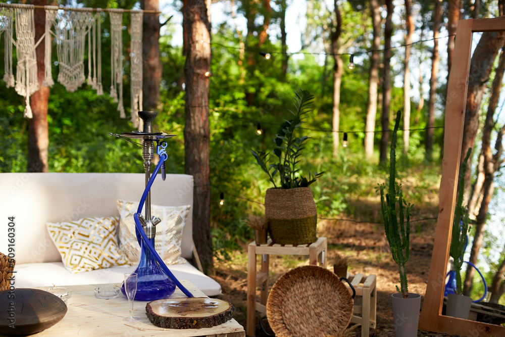 Fotka „Lounge zone with hookah, diy sofa and table of cargo pallets in boho  style on outdoor wedding ceremony venue in pine forest. Bohemian decor.“ ze  služby Stock | Adobe Stock