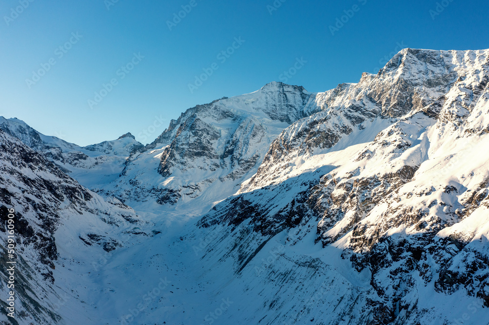 snow covered mountains in winter and glacier valley in the Swiss Alps