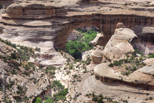 High angle view of natural Sipapu Bridge in White Canyon. Natural bridges national monument. Sandstone arches in the desert of American west. Travelling Utah. White rocks on a hot sunny day of spring. photo