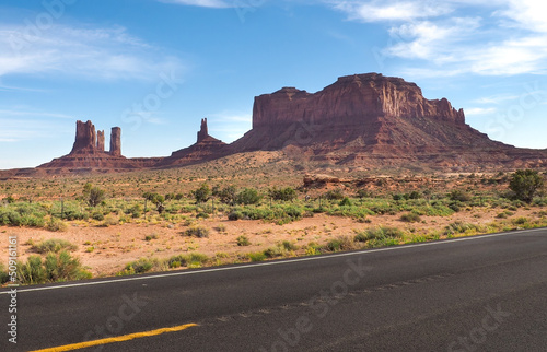 Low angle shot of asphalt road near Rock Door Mesa in Monument Valley, Arizona, USA. Navajo nation area in American southwest. Famoust rock formations in Arizona desert. Red sandstone mesa.