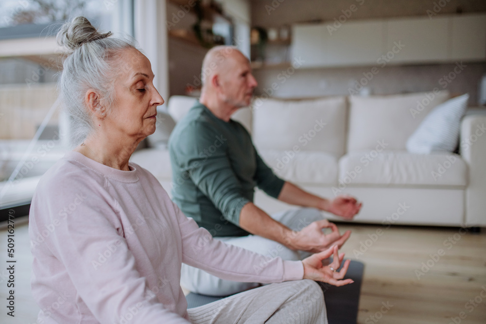 Senior couple doing relaxation exercise together at home. Senior couple doing relaxation exercise together at home.