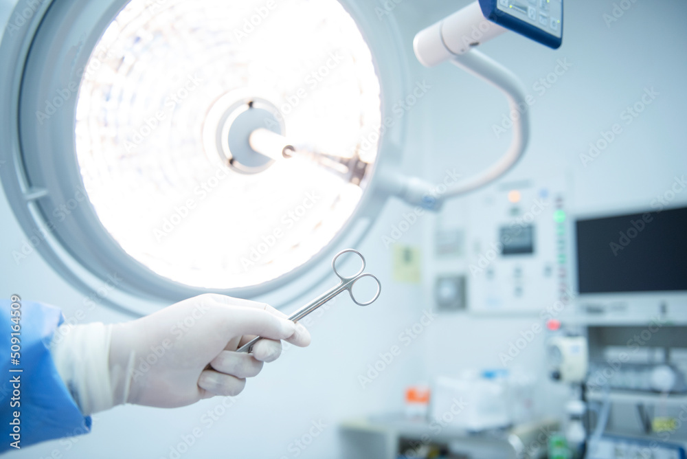 Fototapeta premium A team of Asian surgeons hand out surgical tools to other doctors while operating patients. Life-saving medical team holding medical equipment to save lives of patients. surgery concept