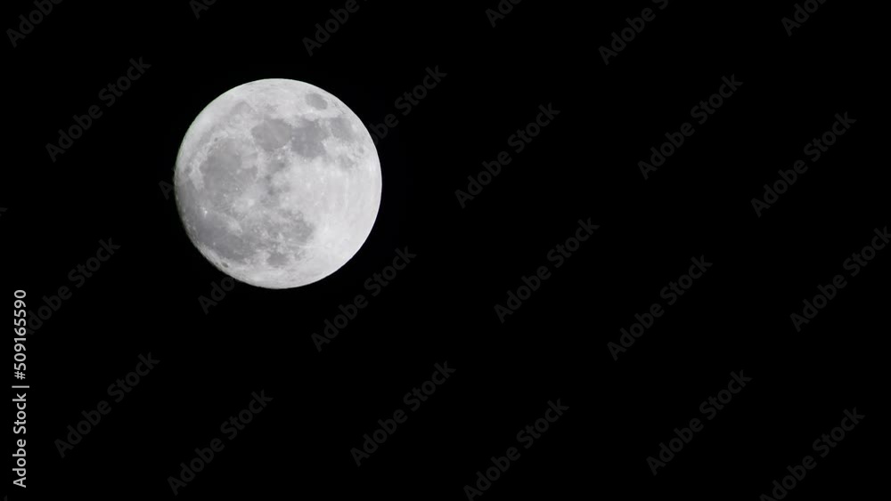 full moon going up on the dark black sky at night without clouds in 4k footage real time full moon going up on the dark black sky at night without clouds in 4k footage real time