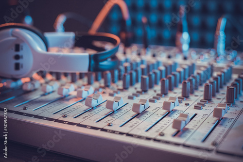 Headphones on sound mixer with faders and music cable jack. Audio equipment in record studio
