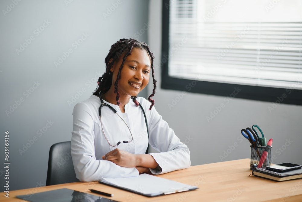 happy young african female nurse working in office. happy young african female nurse working in office.