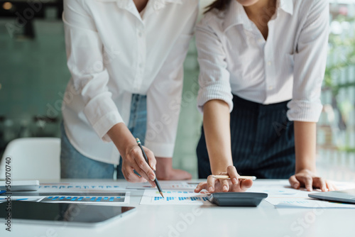 financial, Planning, Marketing and Accounting, Asian woman Economist using calculator to calculate investment documents with partners on profit taking to compete with other companies