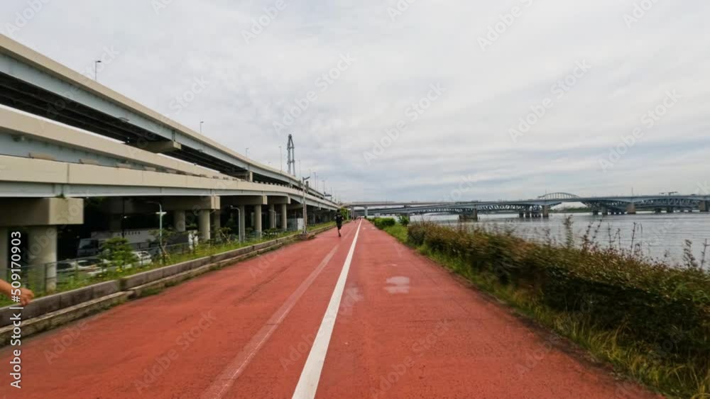 4k Time lapse of a cycle path next to a big river in the city of Tokyo, Japan. 4k Time lapse of a cycle path next to a big river in the city of Tokyo, Japan.