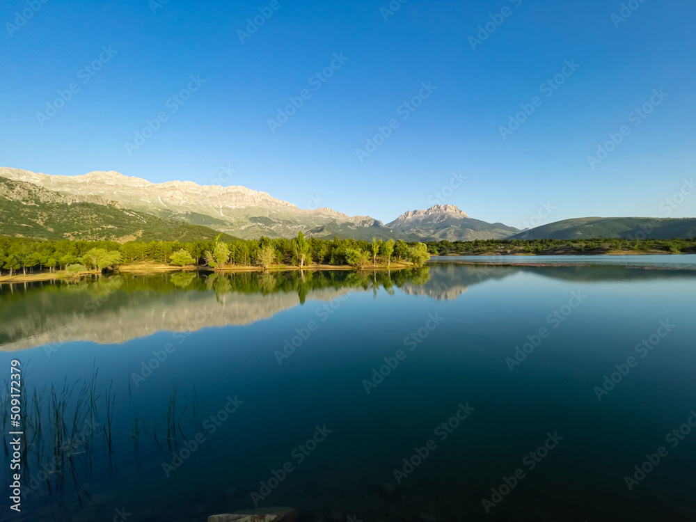 Morning reflections, mystical nature and fascinating mountains in the dam pond