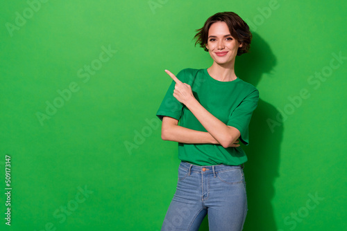 Photo of confident pretty lady wear spring outfit pointing empty space smiling isolated green color background photo