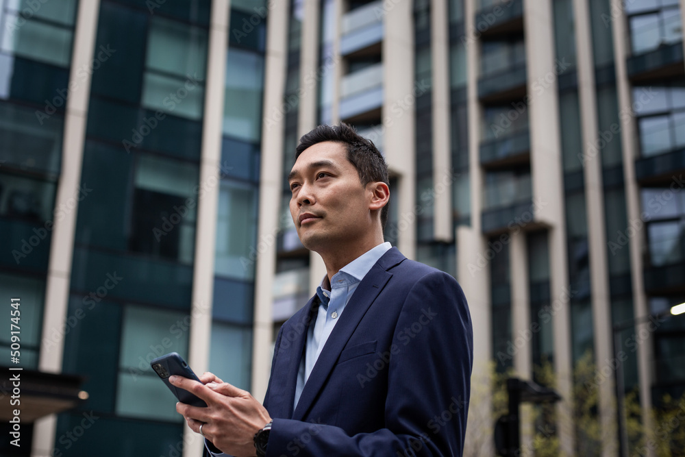 Businessman walking through city using smartphone Businessman walking through city using smartphone