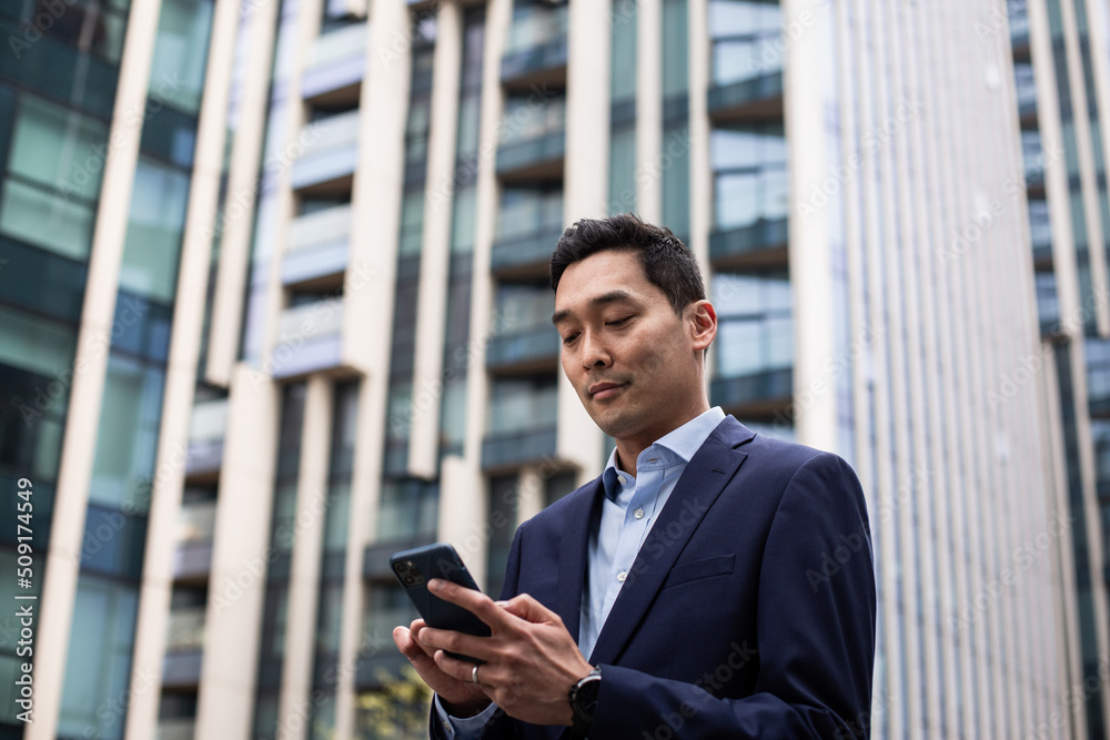 Businessman walking through city using smartphone Businessman walking through city using smartphone