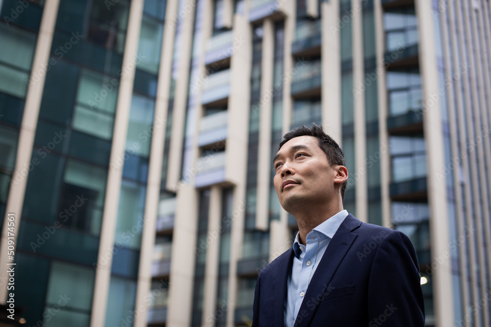 Asian businessman walking through city on his commute Asian businessman walking through city on his commute