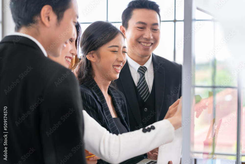 A group of Asian businessmen are gathering ideas to share ideas and offer ideas at a board in the office. with determination, determination and good fun A group of Asian businessmen are gathering ideas to share ideas and offer ideas at a board in the office. with determination, determination and good fun