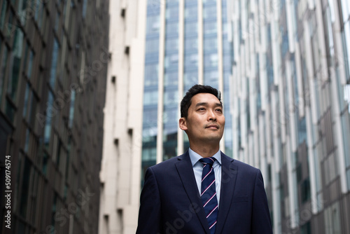 Asian businessman walking through city on his commute photo